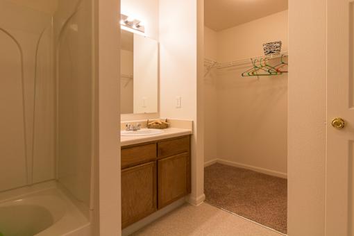 A bathroom with a tub, sink, and a mirror.