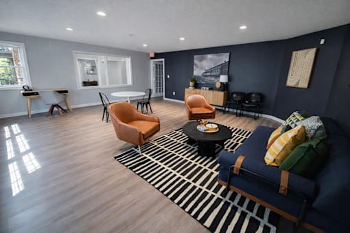 A living room with a blue couch and a striped rug.