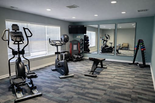 A spacious gym with a variety of equipment including treadmills, exercise bikes, and weight machines.