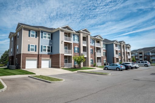 Row of apartment buildings with cars parked in front of them at Mosaic Apartments in Avon, Indiana