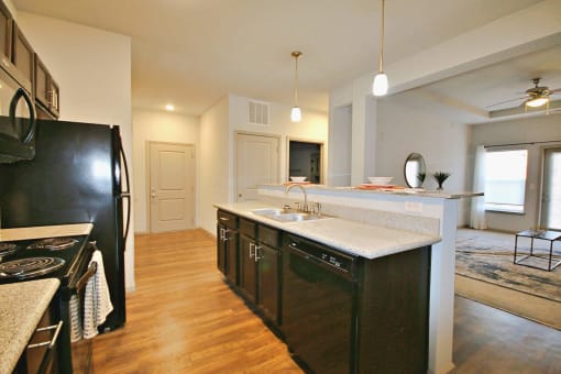 a kitchen with an island and a black refrigerator