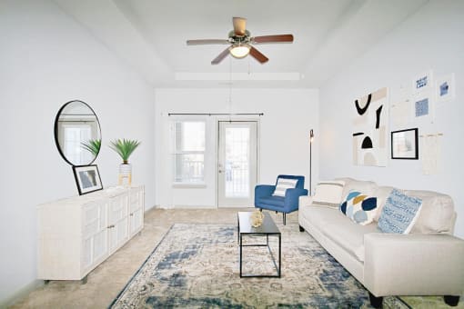 a living room with a white couch and a ceiling fan