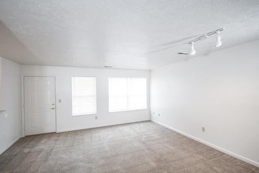 A room with a carpeted floor and white walls.