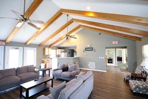 A living room with a grey couch and a wooden floor.