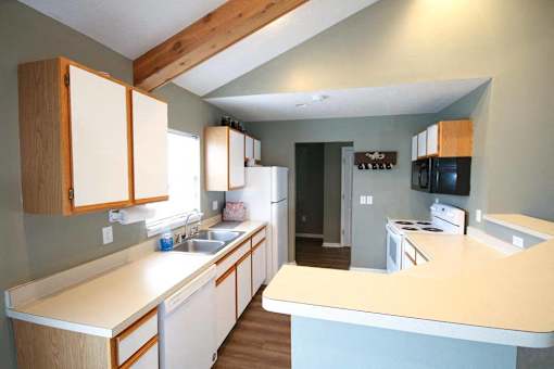 A kitchen with wooden cabinets and a white counter.