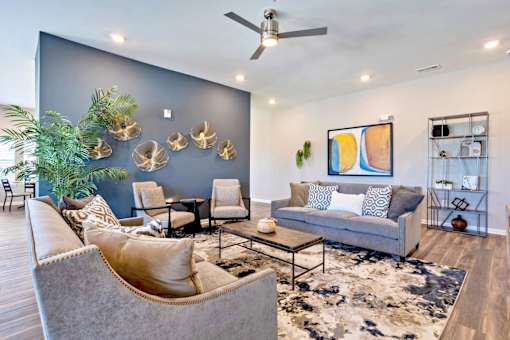 a living room with couches and chairs and a blue accent wall
