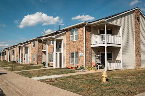 A row of townhouses with a yellow fire hydrant in front of the first one.
