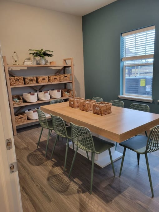 a dining room with a table and chairs and a shelf with baskets at Southern Meadows apartments