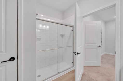 a white bathroom with a shower and a door