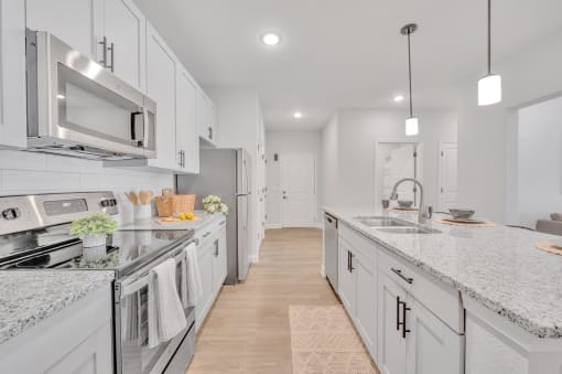 a large kitchen with marble counter tops and white cabinets