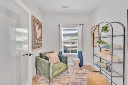 a living room with a green chair and a bathroom with a window