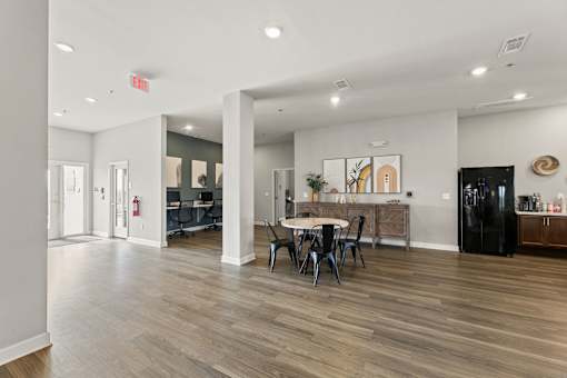 A room with a table and chairs in the middle of the room.
