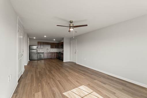 A room with a ceiling fan and wooden flooring.