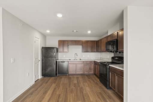 A kitchen with wooden cabinets and black appliances.