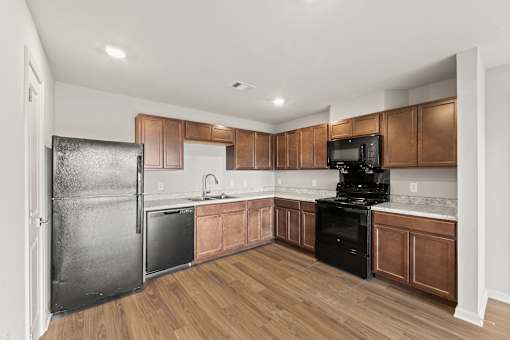 A kitchen with wooden cabinets and black appliances.