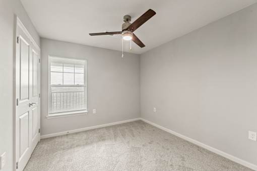 A room with a ceiling fan and a window.