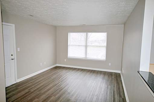 A room with a wooden floor and a window.