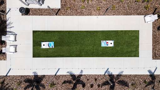 Two corn hole boards on a green lawn.