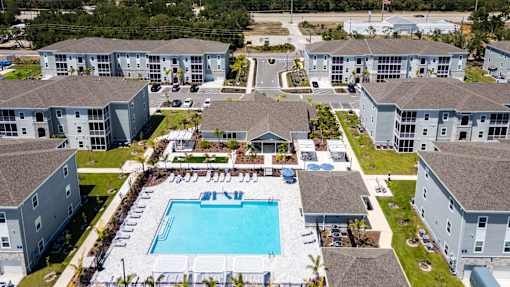 An aerial view of a swimming pool surrounded by apartment buildings.