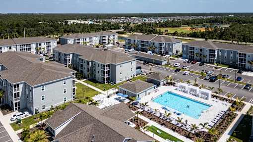 A large apartment complex with a swimming pool in the middle.