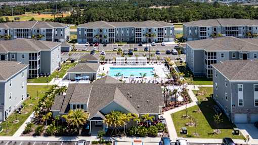 A large apartment complex with a swimming pool in the center.