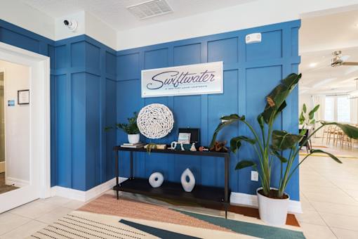 A room with a blue wall and a sign for swiftwater apartments