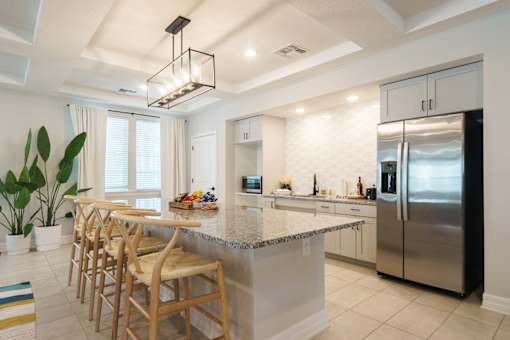 A kitchen with a large island and wooden chairs.