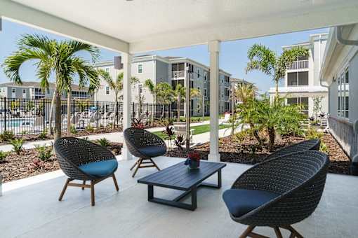 A patio with three chairs and a table.