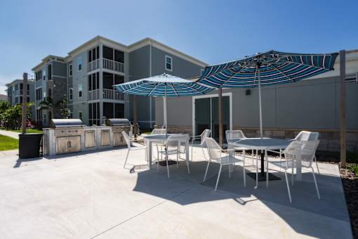 A patio with a table and chairs and an umbrella.