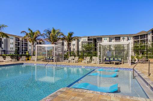 A large swimming pool with a blue tiled edge and a metal fence around it.