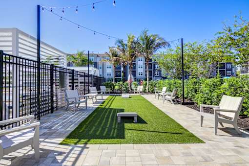 A patio with white furniture and a black fence.