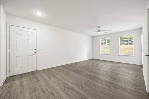 A room with a white door and a ceiling fan.