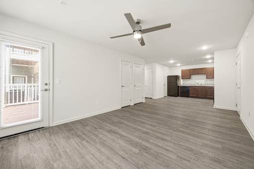 A room with a ceiling fan and wooden flooring.
