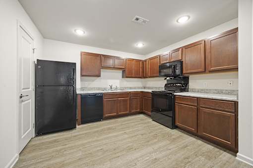 A kitchen with black appliances and wooden cabinets.