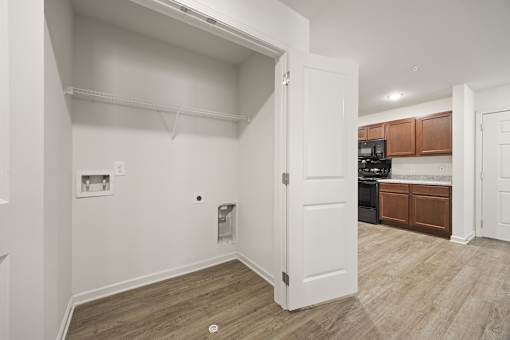 A white door is open to a kitchen area.