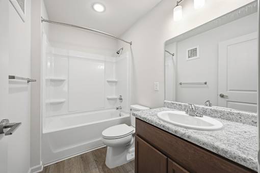 A white bathroom with a toilet, sink, and bathtub.
