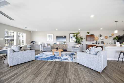 A modern living room with a grey sofa set and a wooden floor.