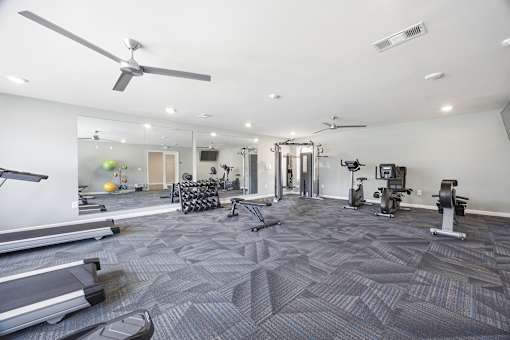 A spacious gym with treadmills, elliptical machines, and other exercise equipment.