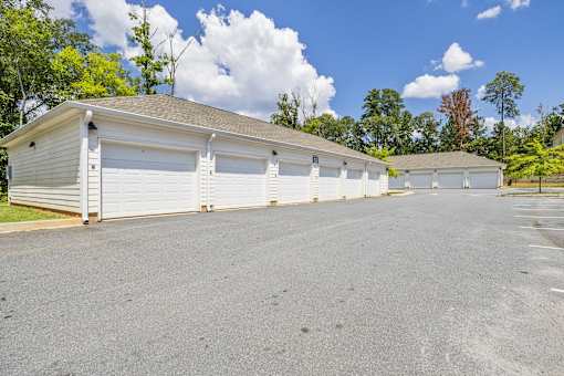 A row of garages with trees in the background.