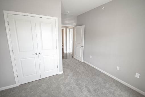 A room with two white doors and a carpeted floor.