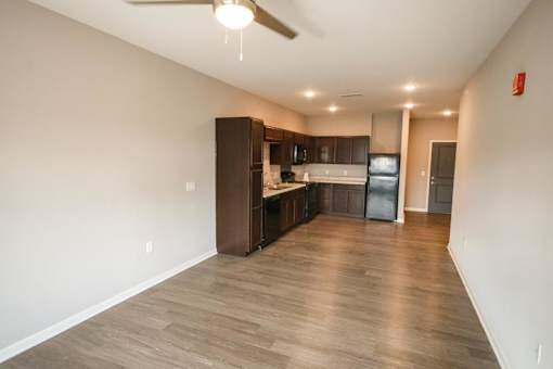 A spacious kitchen with dark wood cabinets and a ceiling fan.