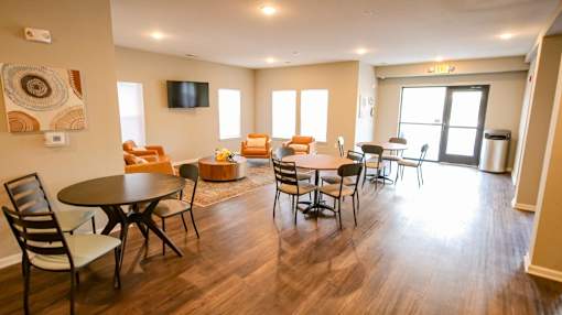 A living room with a TV, chairs, and a dining table.