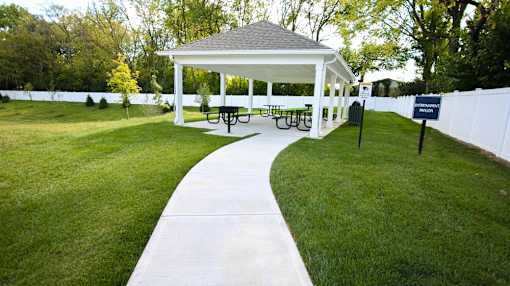 A white gazebo with a walkway leading to it.