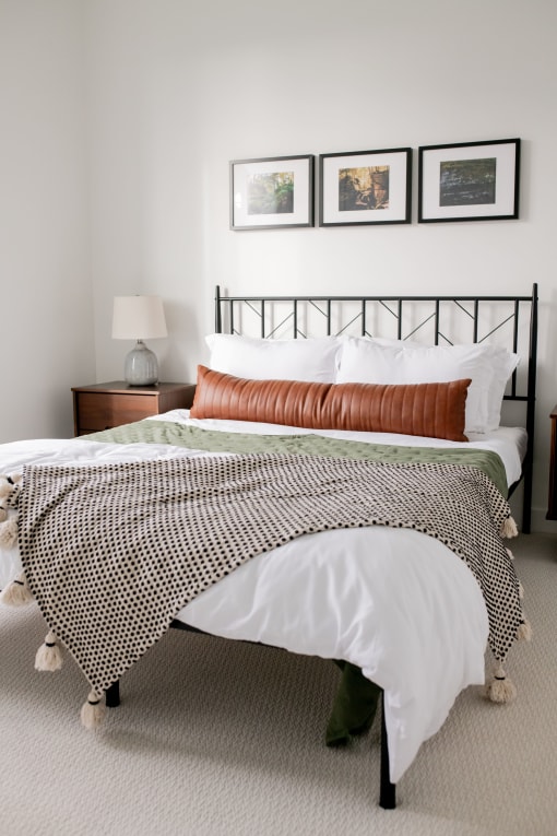 a bedroom with a bed and pictures on the wall