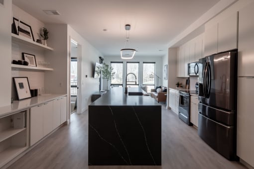 a large kitchen with stainless steel appliances and a black counter top