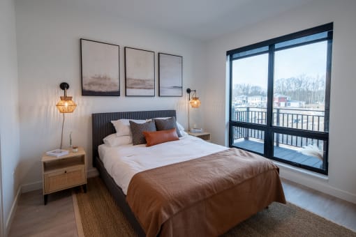 a bedroom with a bed and a large window