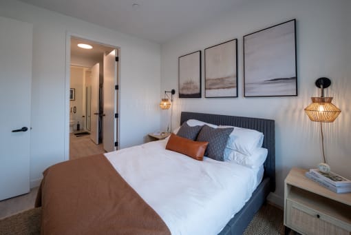 a bedroom with a large bed and paintings on the wall