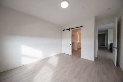 an empty living room with white walls and wood floors