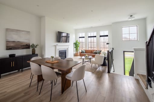 a living room and dining room with a wooden table and chairs