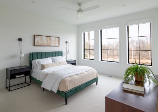 a bedroom with a bed and a table with a potted plant
